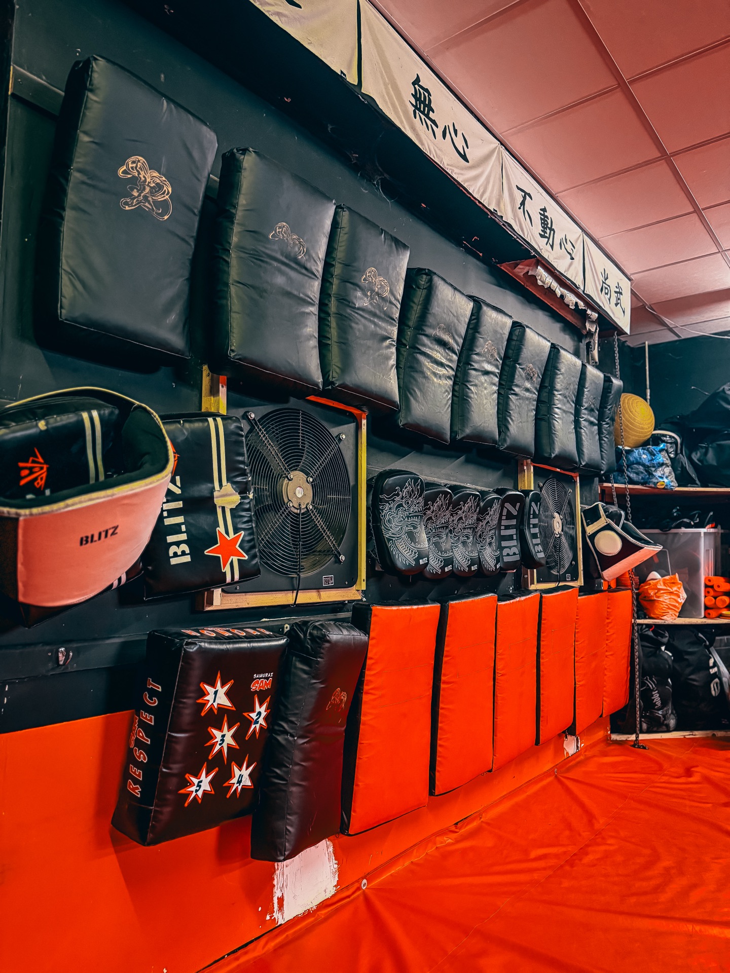 Pads, kick shields and martial arts equipment on the dojo wall